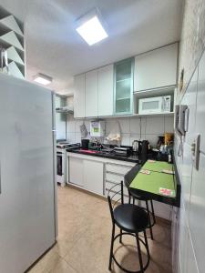 a kitchen with white cabinets and a table and chairs at Diamante em Brasília in Brasília