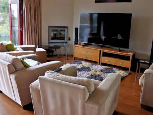 ein Wohnzimmer mit zwei Sofas und einem Flachbildfernseher in der Unterkunft Boavista in Carnforth