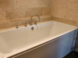 eine Badewanne mit einem Wasserhahn darüber in der Unterkunft Boavista in Carnforth + 21 Fotos