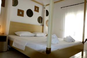 a bedroom with two beds with white pillows and a window at Arco In Pietra in Apolakkiá +15 photos