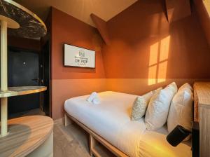 a bed in a room with orange walls at De Pijp Hotel in Amsterdam +64 photos
