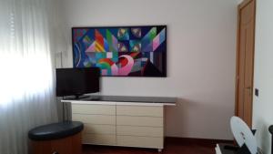 a living room with a tv and a desk with a television at Rosej Bed & Breakfast Putignano in Putignano