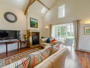 a living room with a couch and a clock on the wall at 3 Bed in Belford oc-89518 in Belford