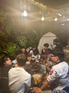 a group of people sitting around a table in a tent at Cherry HomeStay & coffee in Buôn Ðũng