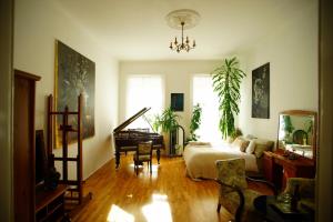 ブダペストにあるAndrassy Art Apartment - Central, Beautiful & Uniqueのリビングルーム(ベッド1台、ピアノ付)