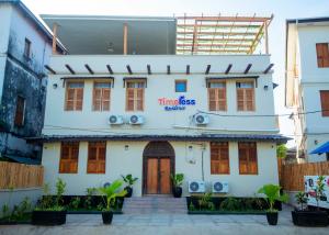 a white house with a sign that reads time less at Timeless Residency in Zanzibar City