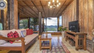 a living room with a couch and a tv at The Joglo at Umah Sunset in Ubud
