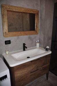 a bathroom with a sink and a mirror at Ilia's Coastal Apartement in Vlorë +6 photos