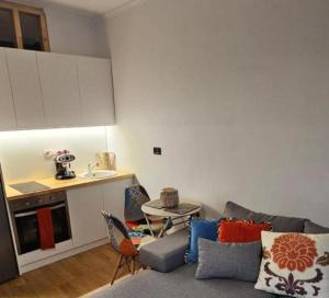 a living room with a couch and a kitchen at Ilia's Coastal Apartement in Vlorë