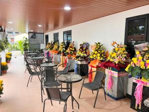 a row of tables and chairs with flowers on them at AURELIA Stay in Brinchang