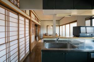 a kitchen with a sink and a microwave at Guest House hopin in Nagano