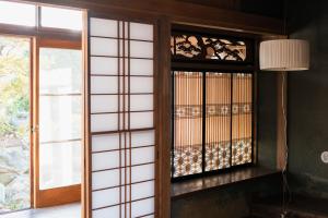 a room with a glass door and a window at Guest House hopin in Nagano