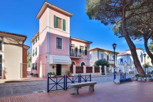 a bench in front of a pink building at Residenza Colombi Goelba in Marina di Campo