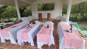 a group of four tables with pink and white covers at Hotel Campestre Mastranto in Villavicencio
