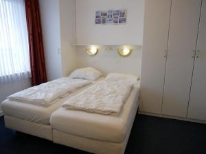 two beds in a small room with lights on the wall at Badhotel Appartementen Callantsoog in Callantsoog +66 photos