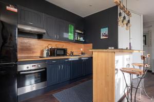 a kitchen with black cabinets and a counter top at Le Princess - Face Nausicaa in Boulogne-sur-Mer