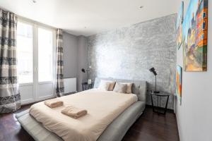 a bedroom with a large bed with two towels on it at Le Princess - Face Nausicaa in Boulogne-sur-Mer