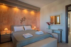 a bedroom with a bed with two towels on it at Villa Sandy Evi by Villa Select in Astérion +23 photos