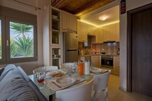 a kitchen with a table with white chairs and a tableablish at Villa Sandy Evi by Villa Select in Astérion