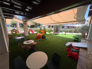 a play area with tables and chairs and a playground at Rimini Balcony Studios - Steps from the Sea in Paphos