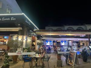 a group of people sitting at tables outside a restaurant at Rimini Balcony Studios - Steps from the Sea in Paphos
