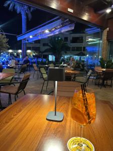 a wooden table with a wine glass on top of it at Rimini Balcony Studios - Steps from the Sea in Paphos