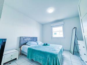 a bedroom with a bed with a blue blanket and a mirror at Apartment 4 pers avec Terrasse in Sète +4 photos