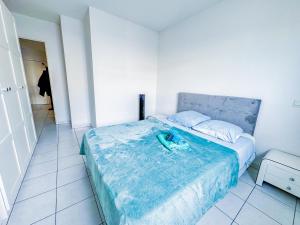 a bedroom with a bed with a blue blanket on it at Apartment 4 pers avec Terrasse in Sète