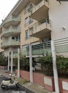 a scooter parked in front of a building at Apartment 4 pers avec Terrasse in Sète