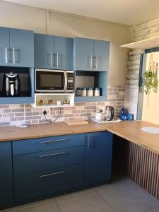 a kitchen with blue cabinets and a counter top at 6 Bayview Seaside Apartment in East London +7 photos
