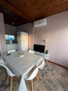 a dining room with a table and chairs and a refrigerator at MiniChino Casa Interna in Pehuajo