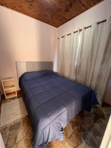 a bedroom with a blue bed in a room at MiniChino Casa Interna in Pehuajo