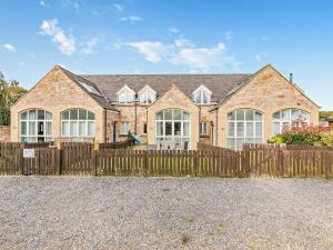 a large brick house with a wooden fence at 3 Bed in Chathill oc-cn001 in Beadnell