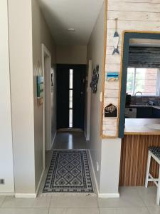 a hallway with a door leading into a kitchen with a rug at 6 Bayview Seaside Apartment in East London