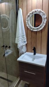 a bathroom with a sink and a shower with a mirror at Refugios de Rio Ilo in Concepción del Uruguay +4 photos