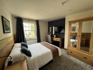 a bedroom with a bed and a window and a mirror at The Star Inn 1744 in Thrussington +24 photos