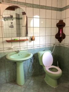 a bathroom with a toilet and a sink at Siesta Riverside Cottages Moshi in Shiri