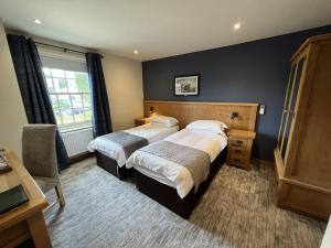 a hotel room with two beds and a window at The Star Inn 1744 in Thrussington