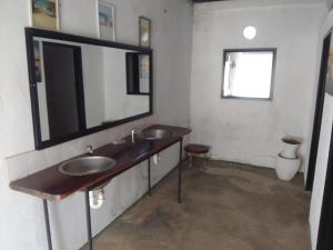 a bathroom with two sinks and a large mirror at Camping Lamadrague in Opuwo