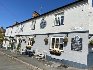 a white building with tables and chairs in front of it at The Star Inn 1744 in Thrussington