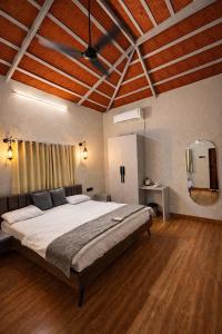 a bedroom with a large bed and a mirror at Shwetik Resort in Khamshet +4 photos