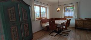 a dining room with a table and chairs and a green door at Chalet Edelweiß in Achenkirch