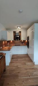 a large kitchen with white cabinets and wooden floors at Chalet Edelweiß in Achenkirch +9 photos