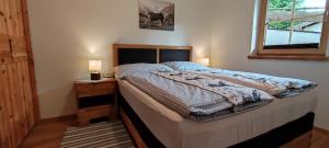 a bedroom with a bed and a window and two lamps at Chalet Edelweiß in Achenkirch