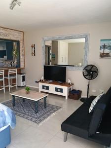 a living room with a couch and a tv at 6 Bayview Seaside Apartment in East London