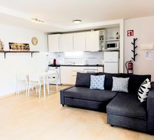 a living room with a couch and a kitchen at cozy flat in Puerto del Rosario