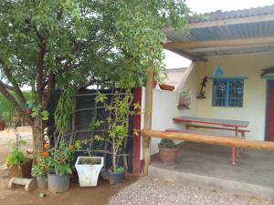 a house with a picnic table and some plants at Camping Lamadrague in Opuwo