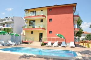 a building with a swimming pool in front of a building at Hotel Jaky SPA Complex in Kranevo