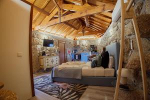 a bedroom with a bed and a stone wall at Refúgios da Natureza in Entre-os-Rios