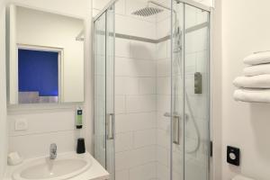 a bathroom with a shower and a sink at Logis Hôtel Maison Voltaire in Amboise +28 photos